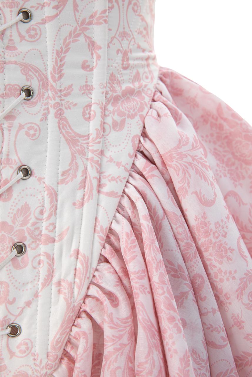 Close-up of the corset's front lace-up eyelets and boning channels in pink and ivory toile print