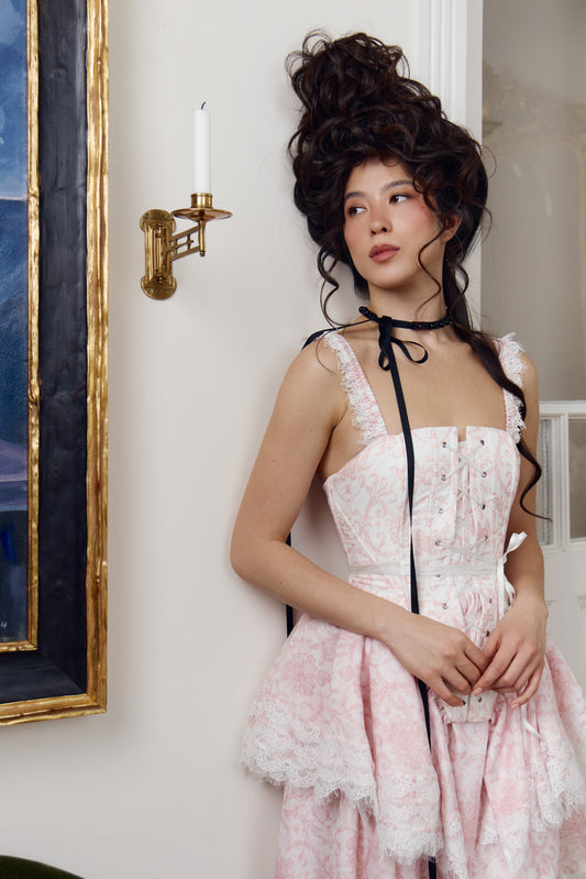 Close-up of the corset bodice in a pink and ivory toile print with front lace-up closure and boning