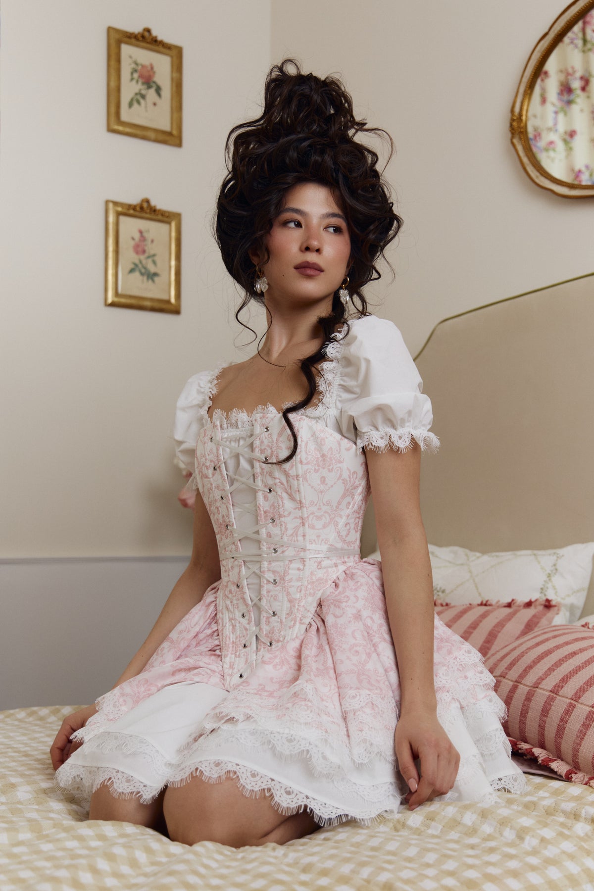 Cotton mini dress three-quarter view with puff sleeves showing above a styled corset overlay